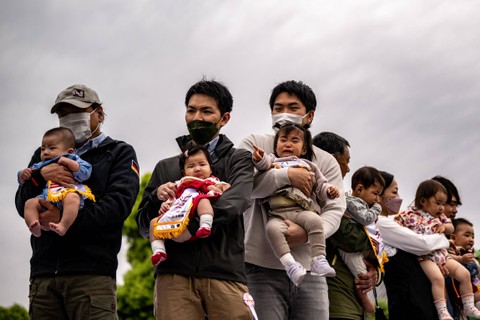 Bayi-bayi yang digendong oleh orang tuanya sebelum memulai pertandingan "Baby-cry Sumo", di kuil Sensoji di Tokyo, Jepang, pada 22 April 2023. Foto: Philip Fong/AFP