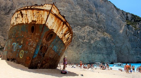 Wisatawan yang tengah menikmati keindahan Pantai Navagio. Foto: Agia/Shutterstock