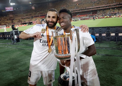 Karim Benzema dan Vinicius dari Real Madrid mengangkat trofi setelah memenangkan pertandingan final Copa del Rey di Estadio de La Cartuja, Seville, Spanyol. Foto: Jon Nazca/Reuters