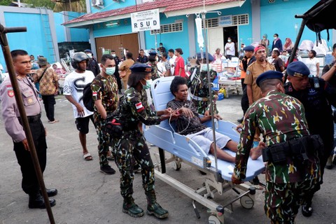 Sejumlah anggota Brimob mengevakuasi pasien ke tenda sementara saat kebakaran Instalasi Rawat Darurat (IRD) RSUD Abepura di Kota Jayapura, Papua, Selasa (9/5/2023). Foto: Gusti Tanati/ANTARA FOTO