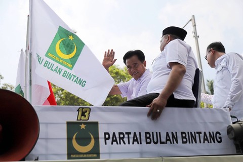 Ketua Umum Partai Bulan Bintang (PBB), Yusril Ihza Mahendra, menyapa para pendukungnya saat tiba di gedung Komisi Pemilihan Umum (KPU), Jakarta, Sabtu (13/5/2023). Foto: Jamal Ramadhan/kumparan