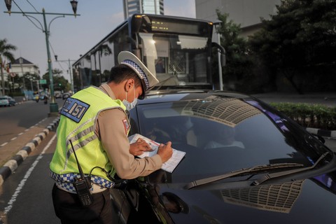 Petugas kepolisian lalu lintas menilang pengendara yang melanggar aturan lalu lintas di kawasan Bundaran Hotel Indonesia, Jakarta, Selasa (16/5/2023).
 Foto: Jamal Ramadhan/kumparan