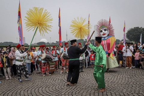 Warga menonton penampilan palang pintu pada gelaran Lebaran Betawi di Monumen Nasional (Monas), Jakarta, Sabtu (20/5/2023). Foto: Jamal Ramadhan/kumparan