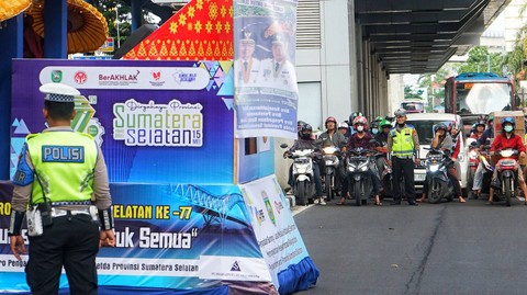 Dua orang petugas Satlantas sedang mengatur konvoi monil hias dalam rangka HUT Provinsi Sumsel ke-77, Minggu (21/5) Foto: abp/Urban Id