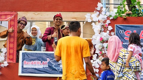 Antusiasme warga yang menyaksikan konvoi mobil hias dalam rangka HUT Provinsi Sumsel ke-77, Minggu (21/5) Foto: abp/Urban Id