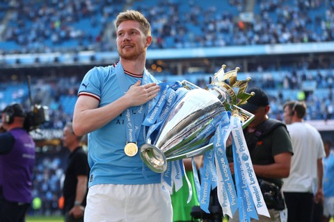 Pemain Manchester City Kevin De Bruyne mengangkat trofi saat selebrasi setelah memenangkan Liga Inggris, di Stadion Etihad, Manchester, Inggris, Minggu (21/5/2023). Foto: Carl Recine/REUTERS