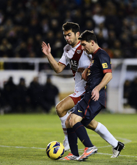 Lionel Messi (kanan) saat masih membela Barcelona berduel dengan Jordi Amat (kiri) yang masih memperkuat Rayo Vallecano dalam laga Liga Spanyol pada 27 Oktober 2012 di Stadion Vallecas di Madrid. Foto: PIERRE-PHILIPPE MARCOU / AFP