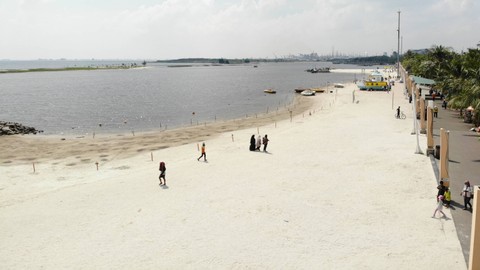 Pengunjung bermain di pasir putih Ancol. Foto: CAHYADI SUGI/Shutterstock