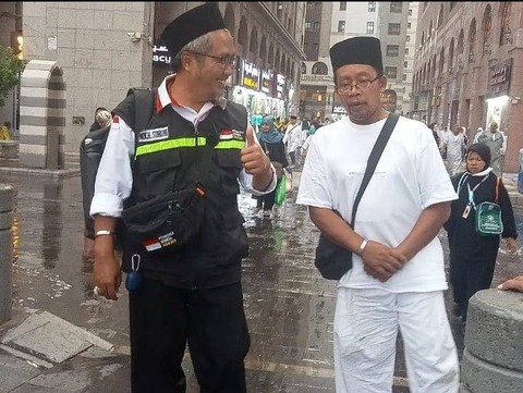 Mahmudin (kanan), jemaah haji Indonesia yang tetap berjalan menuju Masjid Nabawi meski kaki terserang stroke. Foto: Dok. MCH 2023
