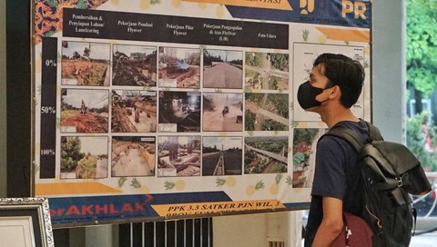 Seorang pengunjung yang melihat arsip lawas berupa proses pembangunan jalan di Palembanh yang dipamerkan di Sriwijaya Expo 2023, Minggu (28/5) Foto: abp/Urban Id