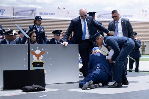 Presiden AS Joe Biden ditolong setelah terjatuh saat upacara kelulusan di Akademi Angkatan Udara Amerika Serikat, tepat di utara Colorado Springs di El Paso County, Colorado, Kamis (1/6/2023). Foto: Brendan Smialowski/AFP