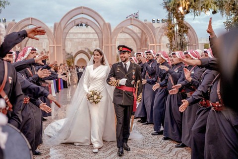 Putra Mahkota Yordania Hussein dan Rajwa Al Saif disambut saat mereka berjalan bersama pada hari pernikahan kerajaan mereka, di Amman, Yordania, Kamis (1/6/2023). Foto: Royal Hashemite Court (RHC)/Handout via REUTERS