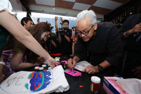 Ganjar saat melukis kaus dengan corak batik megamendung. Foto: Dok. Istimewa