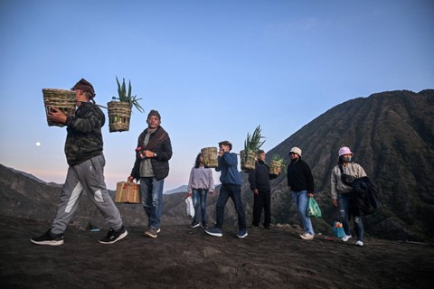 Masyarakat suku Tengger membawa sayur hasil panen untuk dilarung ke kawah pada upacara Yadnya Kasada di Gunung Bromo, Probolinggo, Jawa Timur, Senin (5/6/2023). Foto: Juni Kriswanto/AFP