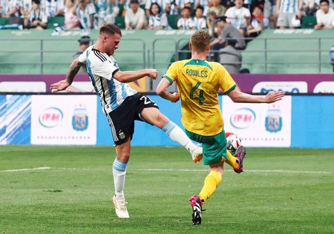 Pemain Argentina Alexis Mac Allister beradu dengan pemain Australia Kyle Rowles di Stadion Workers, Beijing, China. Foto: Thomas Peter/REUTERS