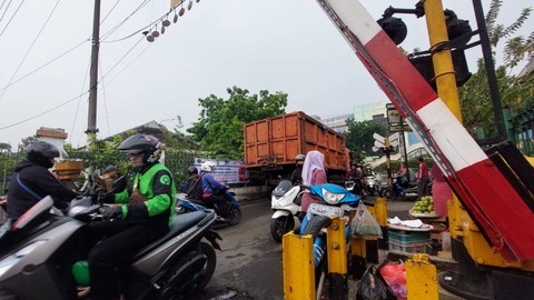 Suasana di pintu perlintasan KA Pasar Minggu yang sedang diuji coba ditutup. Tampak masih banyak kendaraan yang melintas pada Jumat (16/6/2023) pagi. Foto: Nabila Ulfa Jayanti/kumparan