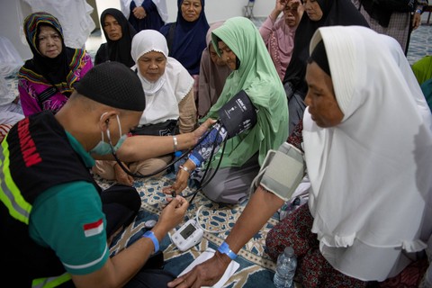 Seorang petugas kesehatan kloter mengecek tensi jemaah lansia kloter SOC 20 usai mengikuti senam di Hotel Bilal Sektor 10, Mekah, Arab Saudi, Sabtu (17/6/2023). Foto: Wahyu Putro A/ANTARA FOTO