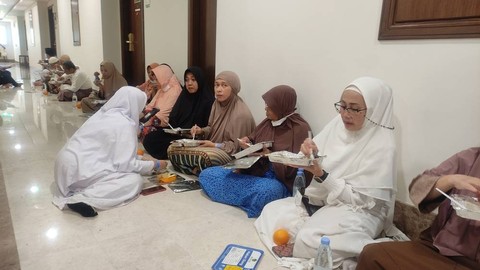 Jemaah haji dari embarkasi Solo (SOC) 50 memutuskan untuk makan bersama di lorong depan kamar mereka. Foto: Ahmad Romadoni/kumparan
