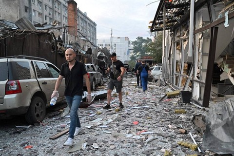 Warga berjalan di antara puing-puing restoran di Kramatorsk, Ukraina timur, yang dihantam roket Rusia, Selasa (27/6). Foto: Genya Savilov/AFP