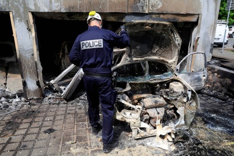 Polisi Prancis memeriksa mobil polisi kota yang dibakar pada malam hari bentrokan malam, di Mons-en-Baroeul, dekat Lille, Prancis utara, Kamis (29/6/2023). Foto: Pascal Rossignol/REUTERS