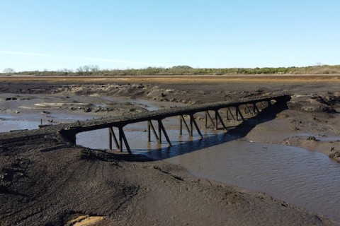 Pemandangan jembatan yang muncul dari bawah waduk Paso Severino di tengah kekeringan parah di Florida, Uruguay, pada Rabu (28/6/2023). Foto: Eitan Abramovic/AFP
