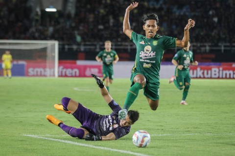 Pesepak bola Persebaya Surabaya Arief Catur Pamungkas (kanan) berusaha melewati penjaga gawang Persis Solo Gianluca Claudio Pandeynuwu (kiri) pada pertandingan BRI Liga I di Stadion Manahan, Solo, Jawa Tengah, Sabtu (1/7/2023). Foto: Mohammad Ayudha/ANTARA FOTO