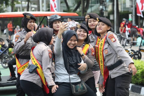 Sejumlah Polwan yang berjaga di area Car Free Day (CFD) diajak berfoto dengan warga di Bundaran HI, Minggu (2/7/2023). Foto: Fitra Andrianto/kumparan
