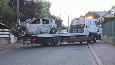 Evakuasi mobil Walikota L'Hay-les-Roses, Vincent Jeanbrun, yang diserbu dan dibakar demonstran di Prancis, Minggu (2/7/2023). Foto: BFMTV/Reuters