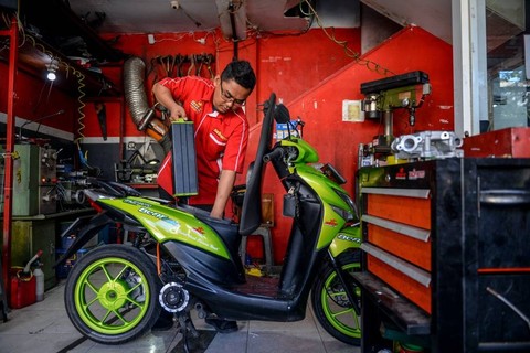 Mekanik melepas baterai motor bbm yang dikonversi ke motor listrik di bengkel Bacip Moto Shop di Bandung, Jawa Barat, Senin (3/7/2023).  Foto: Raisan Al Farisi/ANTARA FOTO