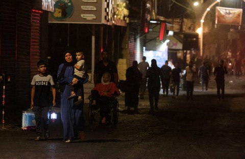 Sejumlah warga mengungsi dari kamp pengungsi Jenin selama operasi militer Israel di Tepi Barat yang diduduki pada Senin (3/7/2023). Foto: Jaafar Ashtiyeh/AFP