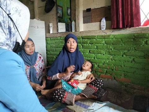 KN balita tampak lemas dalam sakit dipangku oleh ibunya saat dikunjungi warga yang peduli, Desa Tembung, Gg. Istirahat, Kec. Percut Sei Tuan, Deli Serdang, (5/6) sore, foto: Mukhtar Habib