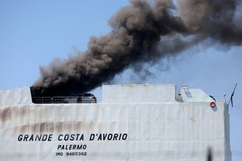 Api berkobar di dekat mobil di kapal kargo yang terbakar, di Port Newark, New Jersey, AS, Kamis (6/7/2023). Foto: Mike Segar/REUTERS