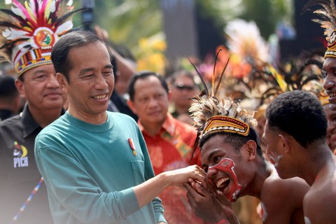 Presiden Joko Widodo (kiri) menyalami peserta Papua Street Carnival di Jayapura, Papua, Jumat (7/7/2023). Foto: Gusti Tanati/Antara Foto