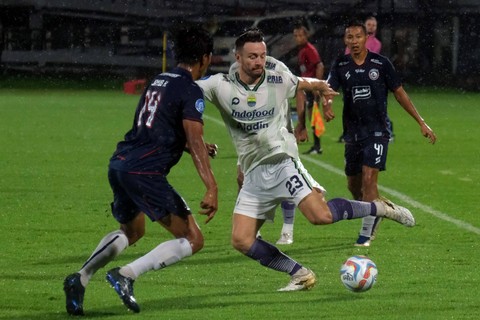 Pemain Persib Bandung Marc Klok (tengah) berusaha melewati pemain Arema FC Jayus Hariono (kiri) dalam pertandingan BRI Liga 1 di Stadion Kapten I Wayan Dipta, Gianyar, Bali, Jumat (7/7/2023). Foto: Nyoman Hendra Wibowo/Antara Foto