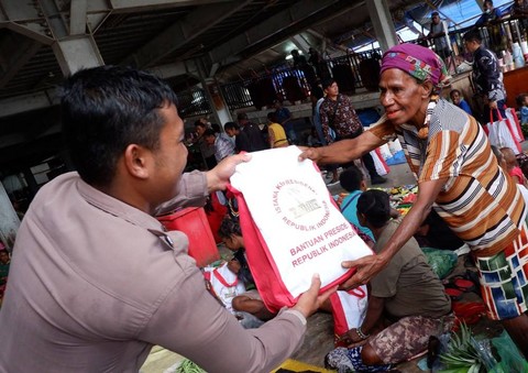Petugas membagikan paket sembako bantuan presiden kepada pedagang yaitu mama-mama Papua di Pasar Pharaa, Distrik Sentani, Kabupaten Jayapura, Papua, Jumat (7/7/2023). Foto: Sakti Karuru/ANTARA FOTO