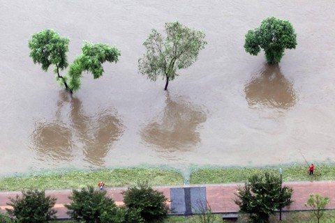 Seorang pria memancing di sungai Han yang banjir akibat hujan lebat di Seoul, Korea Selatan, Jumat (14/7/2023). Foto: Yonhap/via REUTERS 
