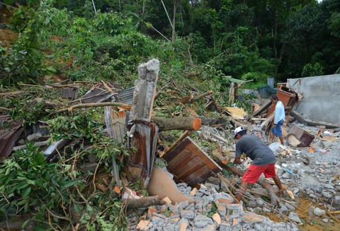 Warga melihat kondisi rumah yang hancur akibat longsor di Mato Aia, Padang, Sumatera Barat, Sabtu (15/7/2023). Foto: Iggoy el Fitra/Antara Foto