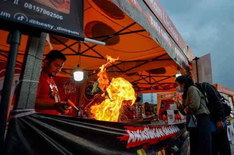 Seorang koki menyelesaikan makanan dalam festival kuliner di Cipadung, Bandung, Jawa Barat, Sabtu (15/7/2023). Foto: Raisan Al Farisi/ANTARA FOTO
