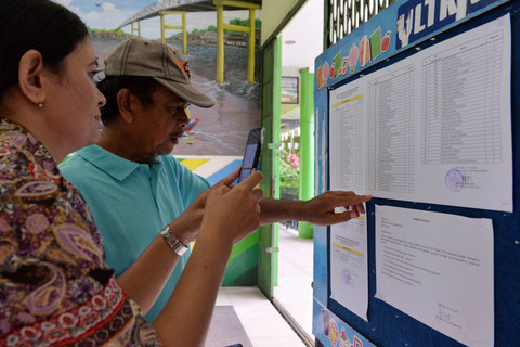Orangtua murid mengecek nama siswa yang dinyatakan lulus pada Penerimaan Peserta Didik Baru (PPDB) di Sekolah Dasar Negeri 34 di Pontianak, Kalimantan Barat, Senin (10/7/2023). Foto: Jessica Helena Wuysang/ANTARA FOTO