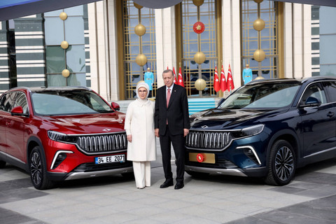 Presiden Turki Recep Tayyip Erdogan (kanan) dan istrinya Emine Erdogan (kiri) foto bersama di depan Togg T10X, mobil listrik produksi dalam negeri pertama Turki di Kompleks Kepresidenan di Ankara, Turki, Senin (3/4/2023).  Foto: Adem ALTAN / AFP