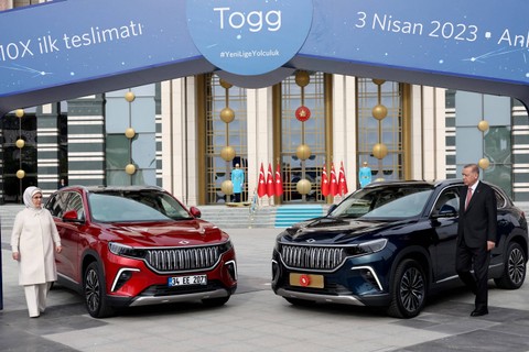 Presiden Turki Recep Tayyip Erdogan (kanan) dan istrinya Emine Erdogan (kiri) foto bersama di depan Togg T10X, mobil listrik produksi dalam negeri pertama Turki di Kompleks Kepresidenan di Ankara, Turki, Senin (3/4/2023).  Foto: Adem ALTAN / AFP