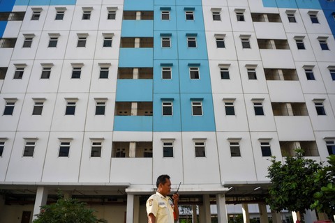 Seorang sekuriti berkomunikasi dengan radio panggilnya di salah satu tower rumah susun sederhana sewa (Rusunawa) Nagrak, Cilincing, Jakarta Utara, Selasa (18/7/2023). Foto: M Risyal Hidayat/Antara Foto