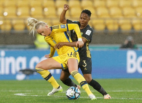 Pemain Timnas Wanita Swedia Stina Blackstenius berebut bola dengan pemain Timnas Wanita Afrika Selatan Bongeka Gamede pada pertandingan Grup G Piala Dunia Wanita 2023 di Stadion Regional Wellington, Wellington, Selandia Baru, Minggu (23/7/2023).  Foto: Amanda Perobelli/REUTERS