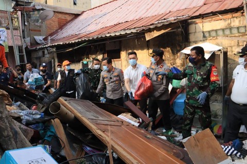 Kapolres Metro Jakarta Selatan Kombes Ade Ary membersihkan puing kebakaran rumah warga di Setiabudi, Jakarta Selatan, Jumat (28/7/2023). Foto: Dok. Istimewa