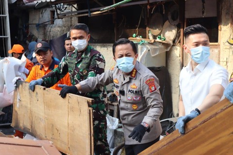Kapolres Metro Jakarta Selatan Kombes Ade Ary membersihkan puing kebakaran rumah warga di Setiabudi, Jakarta Selatan, Jumat (28/7/2023). Foto: Dok. Istimewa