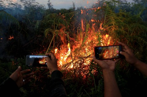 Jurnalis mengambil gambar saat kebakaran lahan gambut di kawasan Desa Suak Raya, Johan Pahlawan, Aceh Barat, Aceh, Jumat (28/7/2023).  Foto: Syifa Yulinnas/ANTARA FOTO