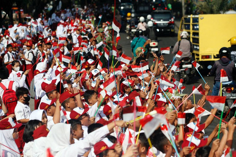 Sejumlah siswa Sekolah Dasar (SD) mengibarkan bendera merah putih di pinggir Jalan Raya Bogor, Cibinong, Kabupaten Bogor, Jawa Barat, Selasa (1/8/2023). Foto: ANTARA FOTO/Yulius Satria Wijaya