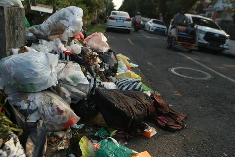 Warga melintas di dekat tumpukan sampah di Alun-Alun Kidul, Yogyakarta, Senin (24/7/2023). Foto: Hendra Nurdiyansyah/ANTARA FOTO