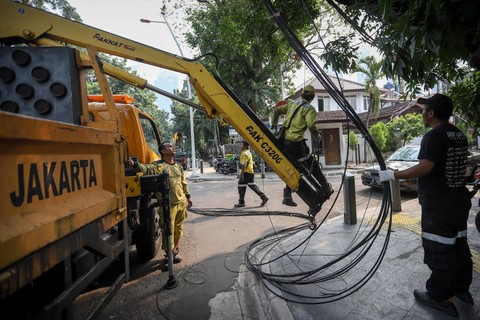 Petugas dari Dinas Bina Marga DKI Jakarta menata instalasi kabel yang semrawut di Jalan Yusuf Adiwinata, Menteng, Jakarta Pusat, Jumat (11/8/2023). Foto: Jamal Ramadhan/kumparan