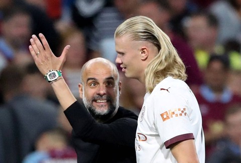 Erling Haaland (kanan) dan Pep Guardiola saat Burnley vs Man City dalam pekan perdana Liga Inggris 2023/24 di Stadion Turf Moor pada Sabtu (12/8/2023) dini hari WIB. Foto: REUTERS/Scott Heppell